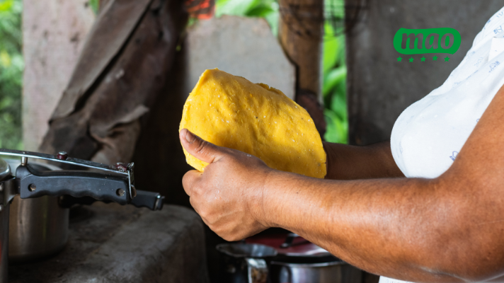 señora armando la arepa de harina de maíz amarillo Mao.